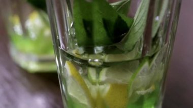 Su nane ve limon ile açık bir cam içine dökülür ve bir buz küpü atılır