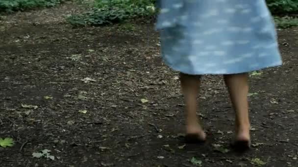 Młoda dziewczyna w niebieskiej sukience boso wiruje w tańcu — Wideo stockowe