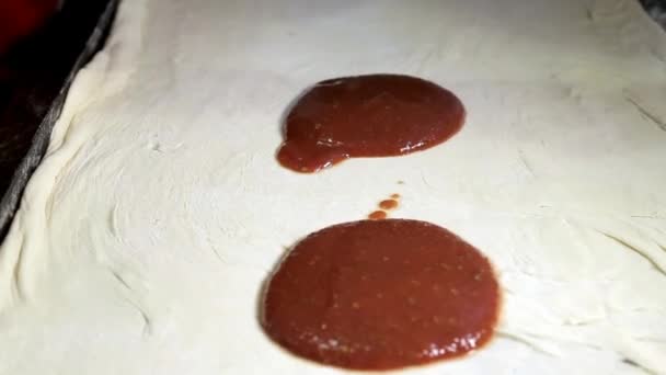 Na massa para pizza espalhar uma grande colher de molho vermelho — Vídeo de Stock