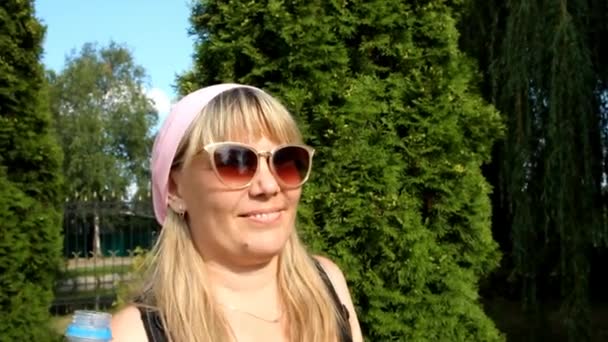 Mädchen Mit Sonnenbrille Und Rosa Kopftuch Trinkt Wasser Aus Einer — Stockvideo