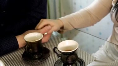 bir adamın elini çay bardak yakınındaki bir el yatıyor