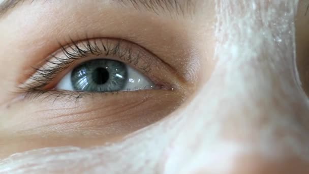 Oční dívka obličej pokrytý bílým krémem, velmi zblízka — Stock video