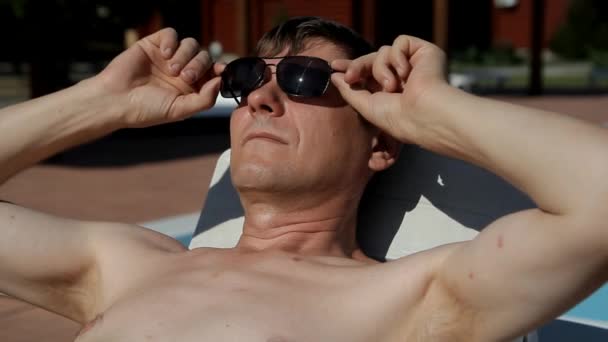 Homem Deitado Uma Cadeira Praia Levanta Seus Óculos Deita Com — Vídeo de Stock