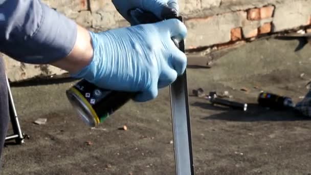 Mans hand holding a rod and painted in black paint from a container — Stock Video