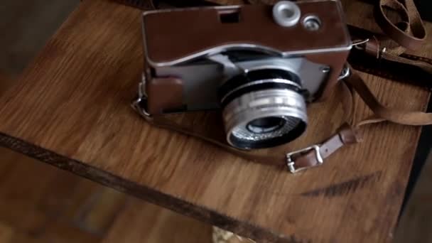Старая камера лежит на краю деревянного стола вид сверху — стоковое видео