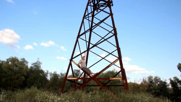 Man Gray Clothes Sitting Rusty Old High Voltage Pole — Stock Video