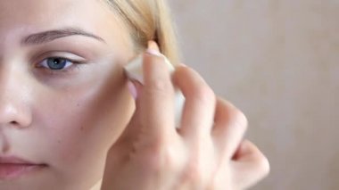 makyaj sanatçının el genç Avrupalıların yakın çekim yüzünde krem koymak