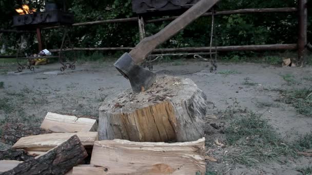 一把斧子伸出来的树桩 火在火盆里燃烧 — 图库视频影像