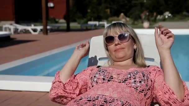 Rubia mujer en brillante pareo dispara gafas de sol — Vídeos de Stock