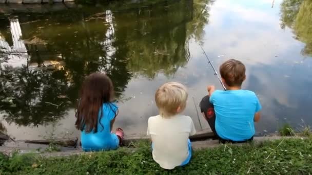 Three Small Children Sit Shore Pond Fishing — Stock Video