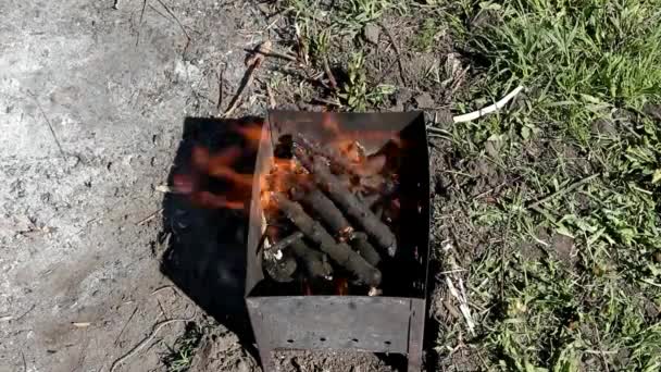男性の手が燃える火鉢 上面に小さな破片を投げる — ストック動画