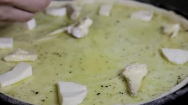 eldivenli elleri adet peynirli bir pizza yüzeye yaymak