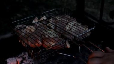 Erkek el kömürlerin üzerinde et düzeltiyor