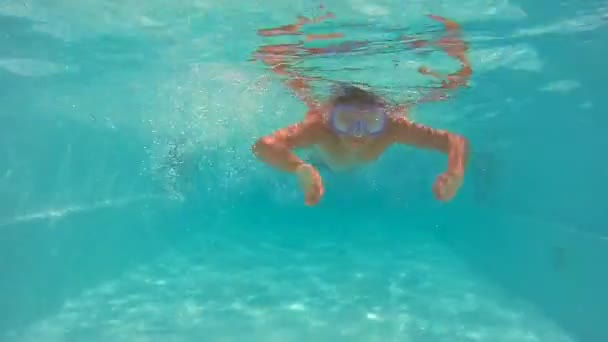 穿着紫色面具漂浮在水下的游泳池里的青少年 — 图库视频影像