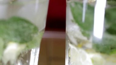 eller gözlük şeffaf ferahlatıcı bir içki ile tüpler yerleştirin ve onları bardan yakın çekim