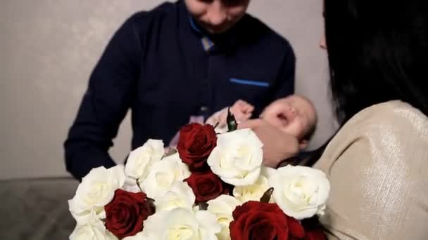 美しい花束を持つママの隣に お父さんは叫ぶ子供を抱いている — ストック動画