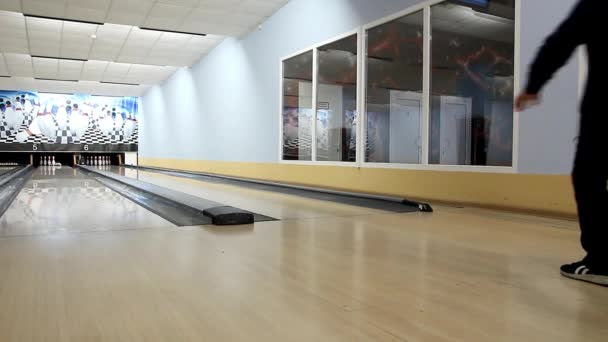 Boy in a black tracksuit throws the ball on the track bowling — Stock Video