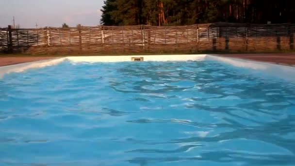 Muž s hrnci skákající do bazénu — Stock video