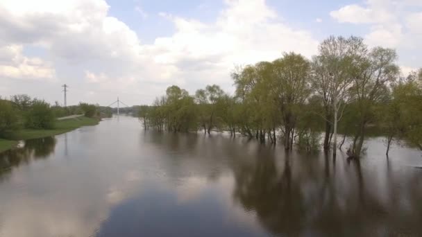 摄像机飞过河上的溢流，远处有一座桥 — 图库视频影像