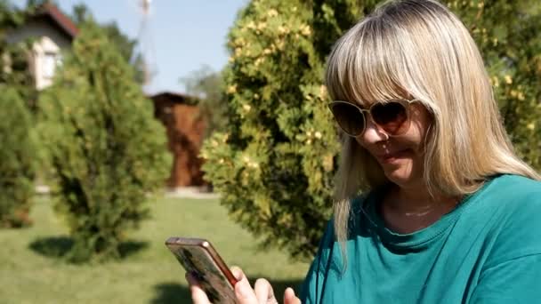 Mujer Rubia Sentada Césped Verde Marca Número Habla Por Teléfono — Vídeo de stock