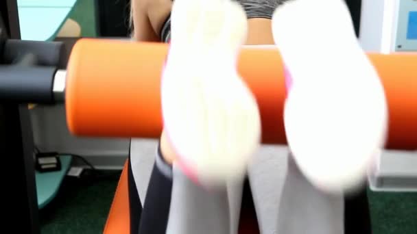 Flexión de las piernas femeninas en un simulador, plano cerrado — Vídeo de stock