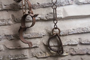 slave handcuffs holding from a wall clipart