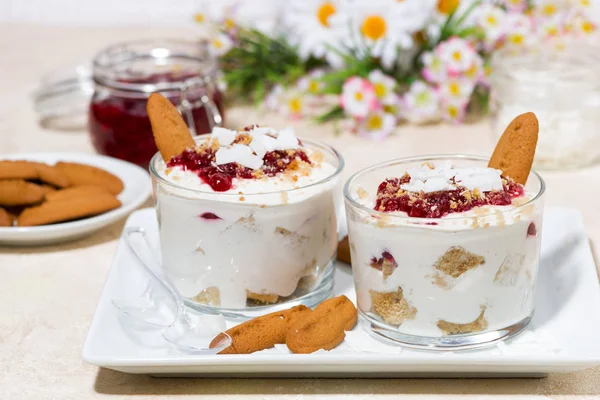 dessert in a glass with cookies, cream and jam, horizontal