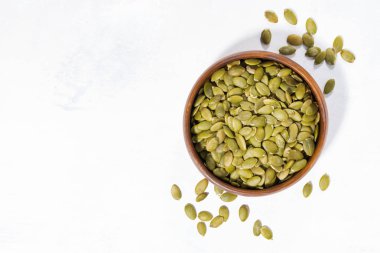 Beyaz arka planda, üstten görünüm yatay kabak çekirdeği ile kase