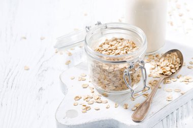 Yulaf gevreği ve şişe süt beyaz ahşap zemin, üstten görünüm, yatay