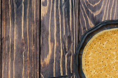 Geleneksel ince krep yerken üzerine bir tabak ve ahşap arka plan, üstten görünüm