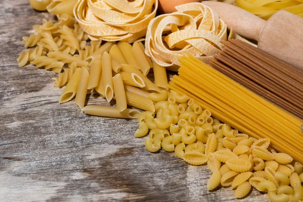 Different Dry Pasta Wooden Board Top View Horizontal — Stock Photo, Image