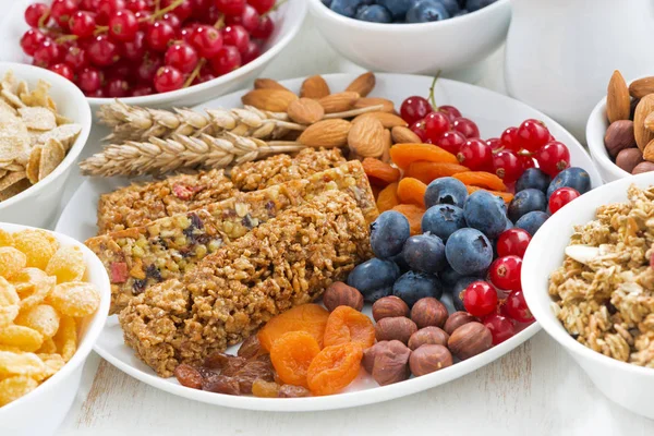 assortment of cereal muesli bars, fresh and dried fruit for breakfast, horizontal, closeup