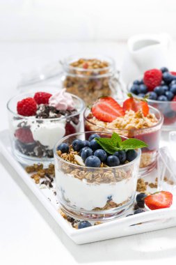 Beyaz ahşap tepsi, üstten görünüm bardaklarda taze çilek ile tatlı tatlılar