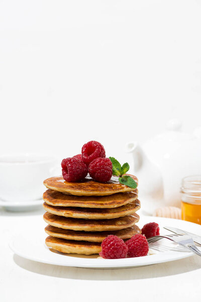stack of pancakes with fresh raspberries for breakfast, vertical closeup