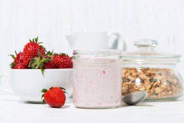 tatlı çilekli yoğurt, granola ve beyaz arka planda, closeup taze çilek