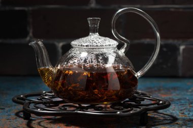 karanlık bir arka planda portre yatay bir cam demlik çay masala
