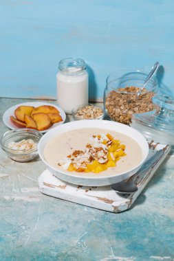 mango, Hindistan cevizi ve sağlıklı kahvaltı, dikey en iyi görünüm için fındık ile güler yüzlü kase