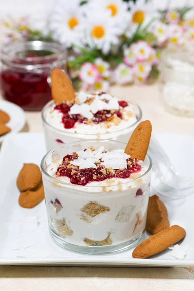 dessert in a glass with cookies, cream and berries jam, vertical photo