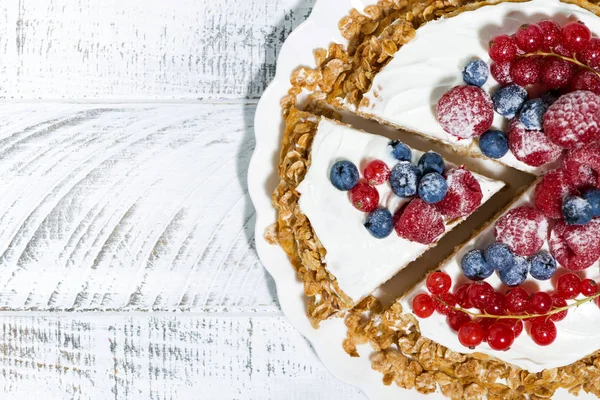 healthy sweet oatmeal cake with yoghurt and fresh berries on white background, closeup