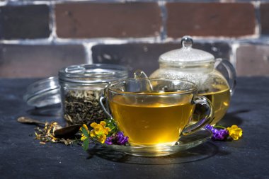 karanlık bir arka planda, yatay aromatik otlar ile çay