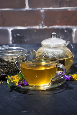 karanlık bir tabloda dikey closeup aromatik otlar ile çay