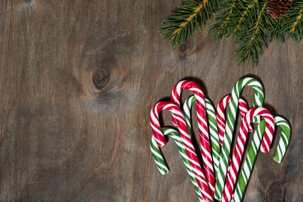 Noel şeker ürün yelpazesine şekerler ve köknar gri arka plan üzerinde üstten görünüm şubeleri