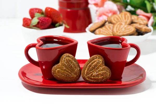 Deux tasses à café rouges et biscuits en forme de coeur sur table blanche — Photo