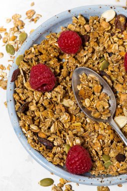 tatlı granola plaka ve taze ahududu, dikey üstten görünüm