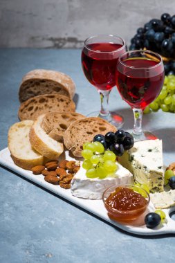 peynir tabağı, taze ciabatta, üzüm ve iki bardak kırmızı şarap, dikey fotoğraf
