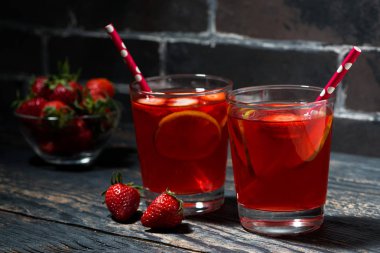 koyu ahşap arka plan, closeup çilek limon limonata iki bardak