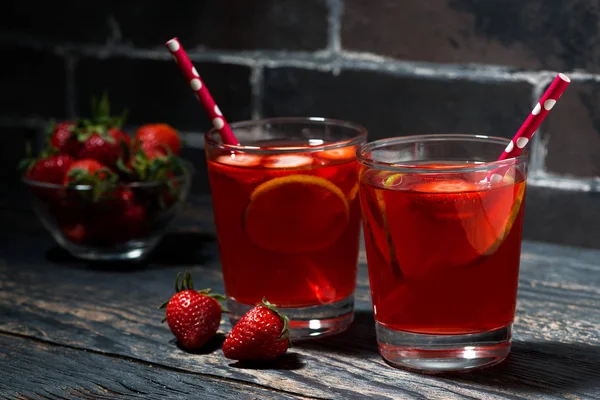 koyu ahşap arka plan, closeup çilek limon limonata iki bardak