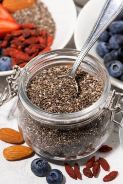 Chia tohum bir kavanoz, çilek ve fındık için sağlıklı bir kahvaltı, üstten görünüm dikey