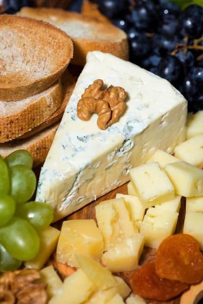 木の板 パンとフルーツ クローズ アップ垂直にチーズの盛り合わせ — ストック写真