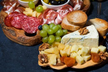 Tahtadaki peynir tabağı, ekmek, meyve ve soğuk et, yakın plan.